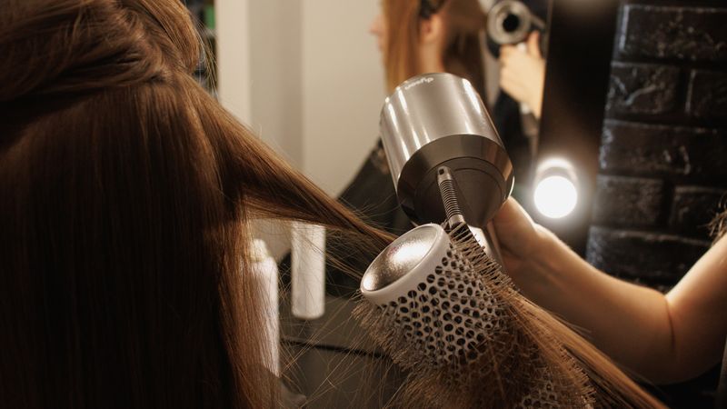 Cabeleireira fazendo escova em uma cliente no salão de beleza